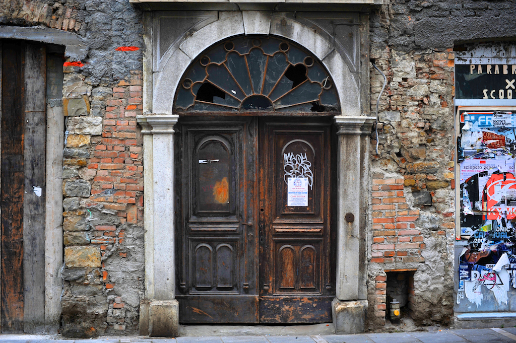 Old door in Trieste with graffiti