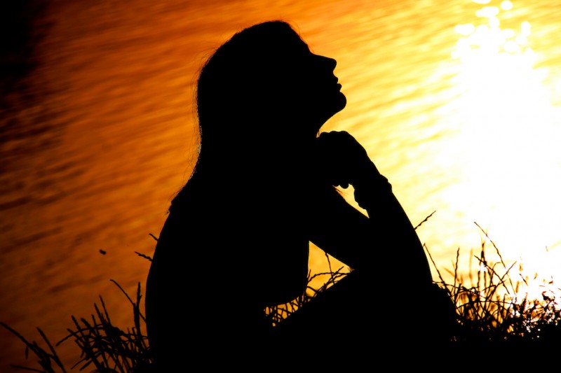 Woman by lake at sunset