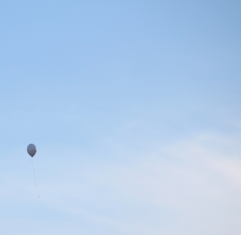 A single balloon floats into the sky