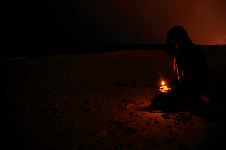 Holding a candle on the beach