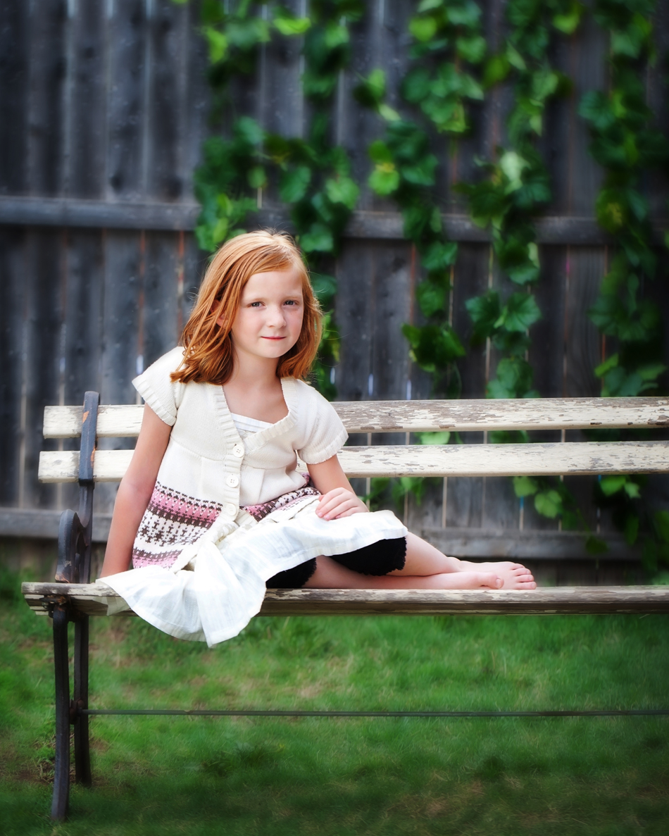 Redheaded girl sitting on a bench
