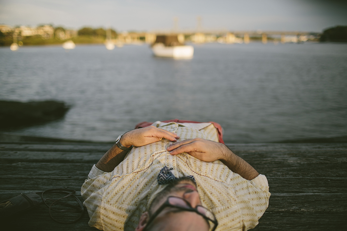 man lying next to the water